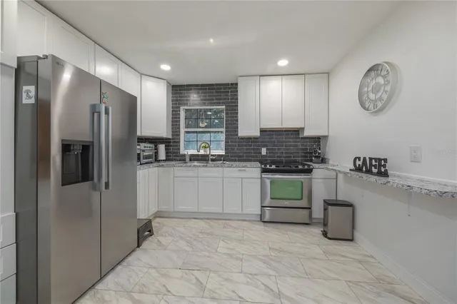 a kitchen with a refrigerator and a stove top oven