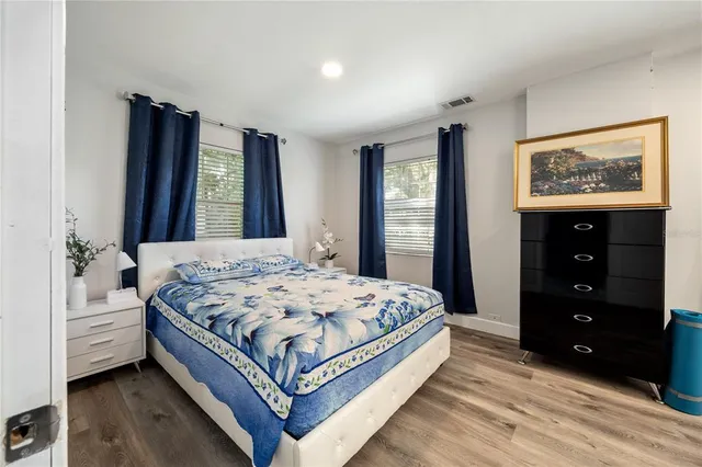 a view of a bedroom with cabinet mirror and window