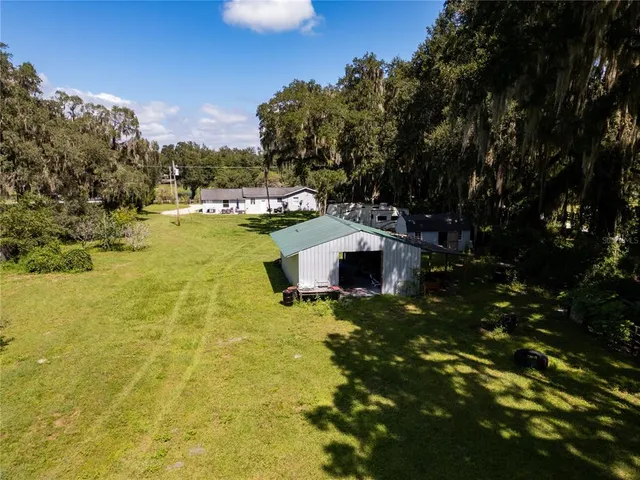 a view of a house with a yard garage and outdoor seating