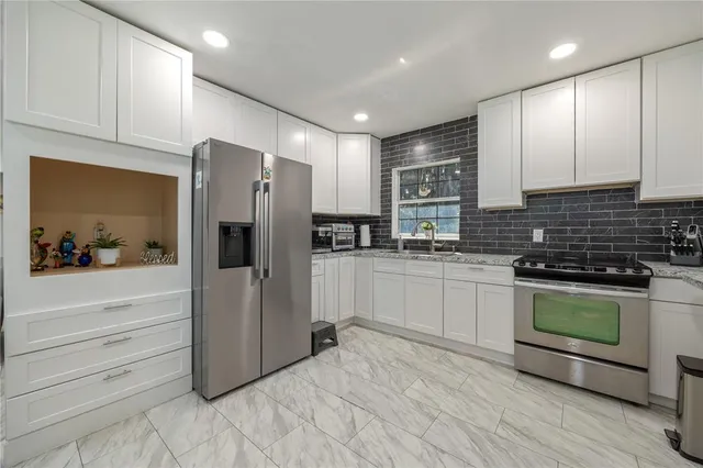 a kitchen with stainless steel appliances granite countertop a refrigerator and a stove top oven