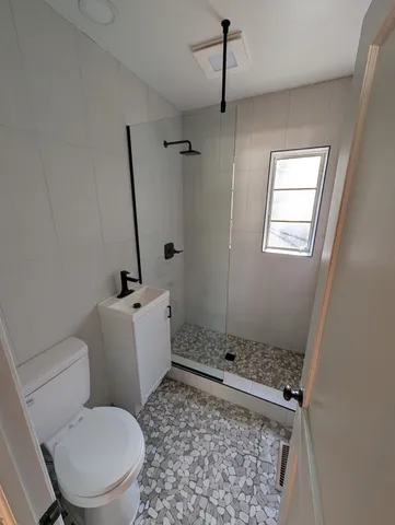a bathroom with a toilet and a shower