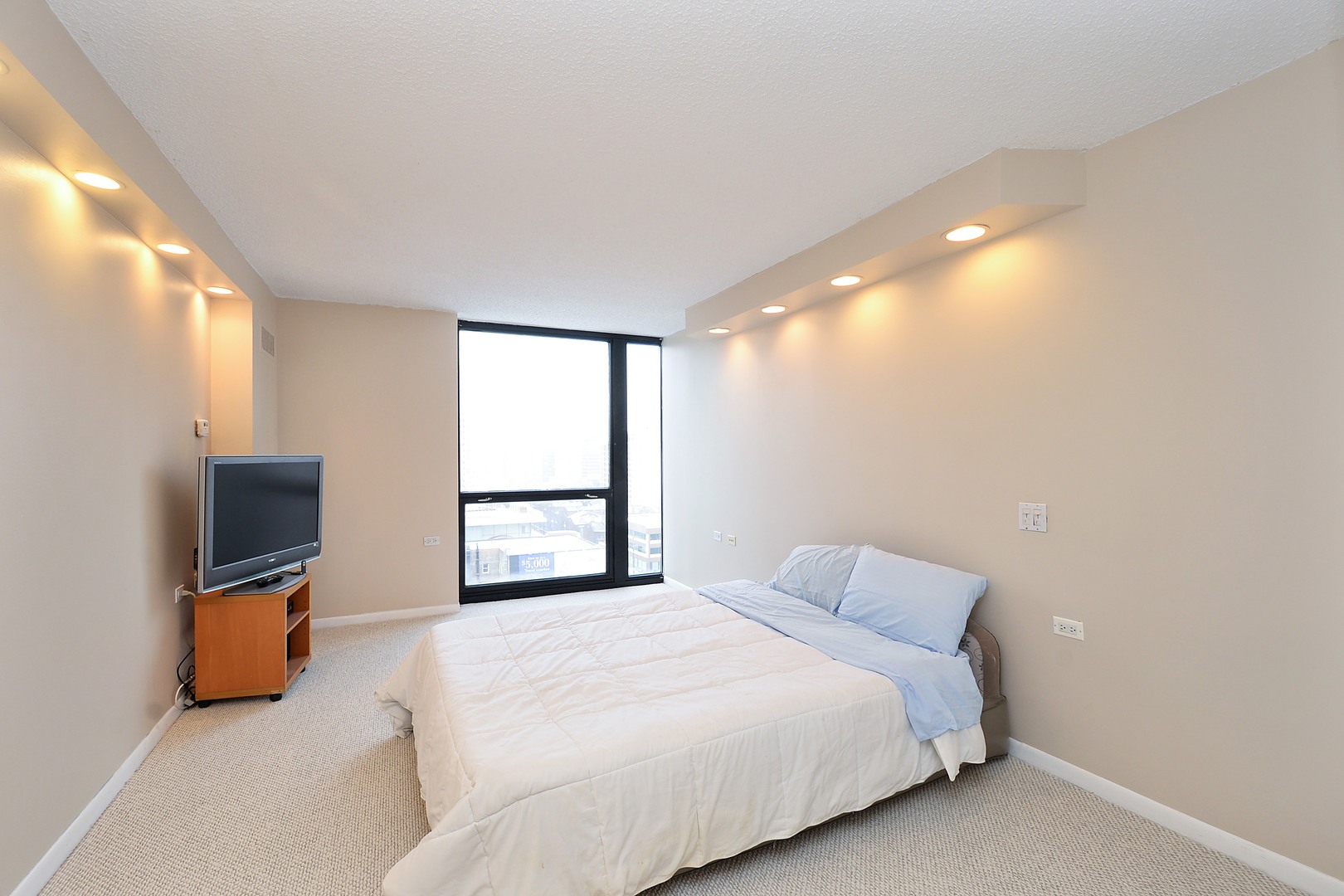 1122 North Clark Street, Unit 1203 Chicago, IL 60610 - Photo 9 of 22 a bedroom with a bed and a flat screen tv