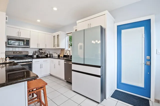 a kitchen with stainless steel appliances granite countertop a refrigerator and a stove top oven