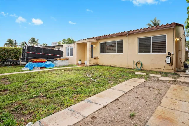 a view of a house with backyard and sitting area