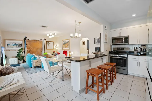 a kitchen with stainless steel appliances kitchen island granite countertop a sink and cabinets