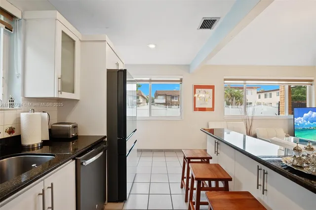 a kitchen with granite countertop a sink and a stove top oven