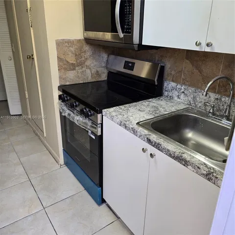 a kitchen with granite countertop a sink and a stove