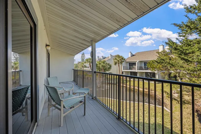 a view of a balcony with wooden floor and iron stairs
