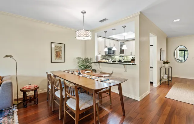 a view of a dining room and livingroom with furniture wooden floor a chandelier