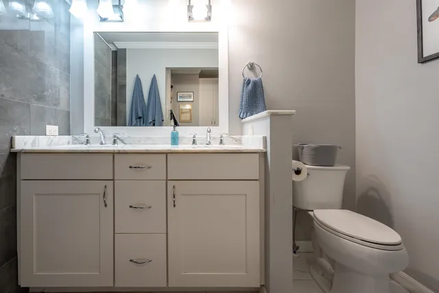 a bathroom with a toilet sink vanity and mirror