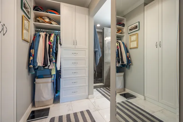 a view of walk in closet with clothes and shoes