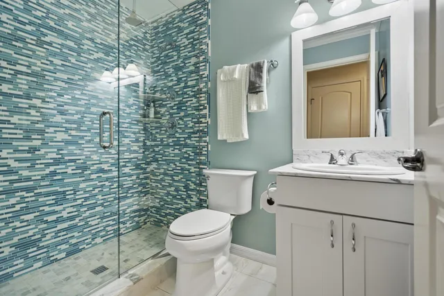 a bathroom with a toilet sink vanity and mirror