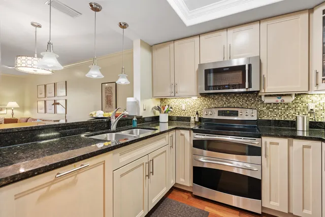 a kitchen with granite countertop cabinets stainless steel appliances and a sink