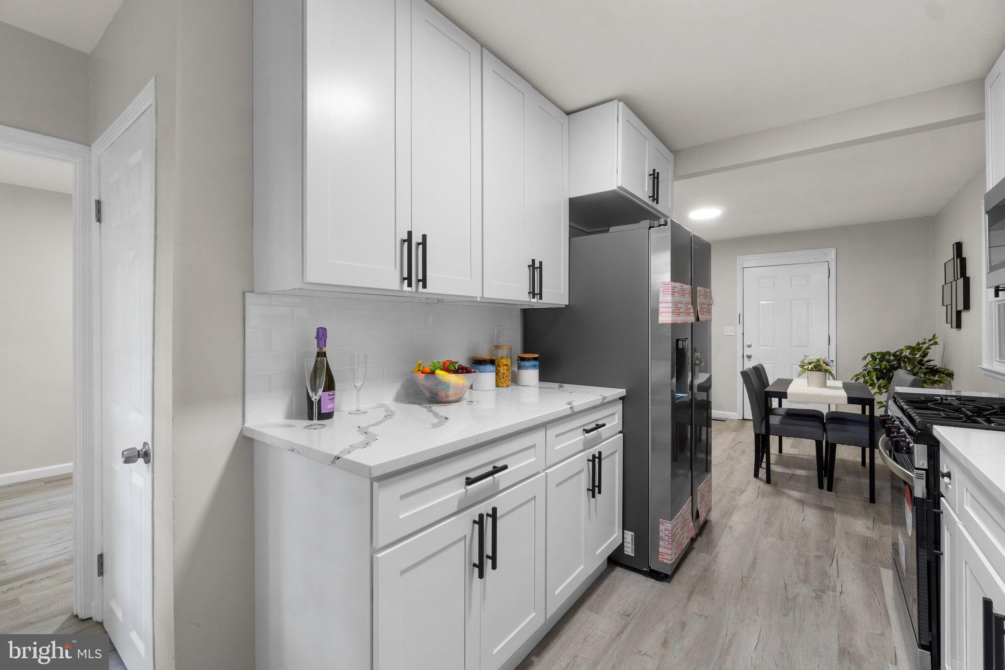 3648 Clifmar Road Windsor Mill, MD 21244 - Photo 8 of 22 a kitchen with white cabinets and sink