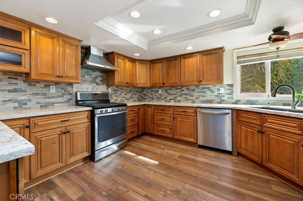 14231 Alexander Street Riverside, CA 92508 - Photo 12 of 36 a kitchen with stainless steel appliances granite countertop wooden cabinets a sink a stove a refrigerator and island with wooden floor