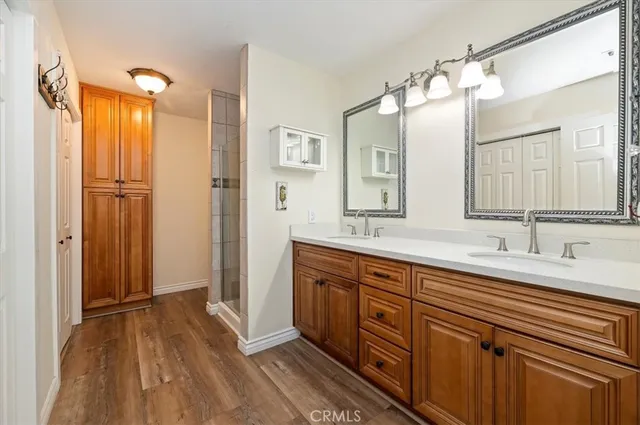 a spacious bathroom with a double vanity sink a mirror and shower