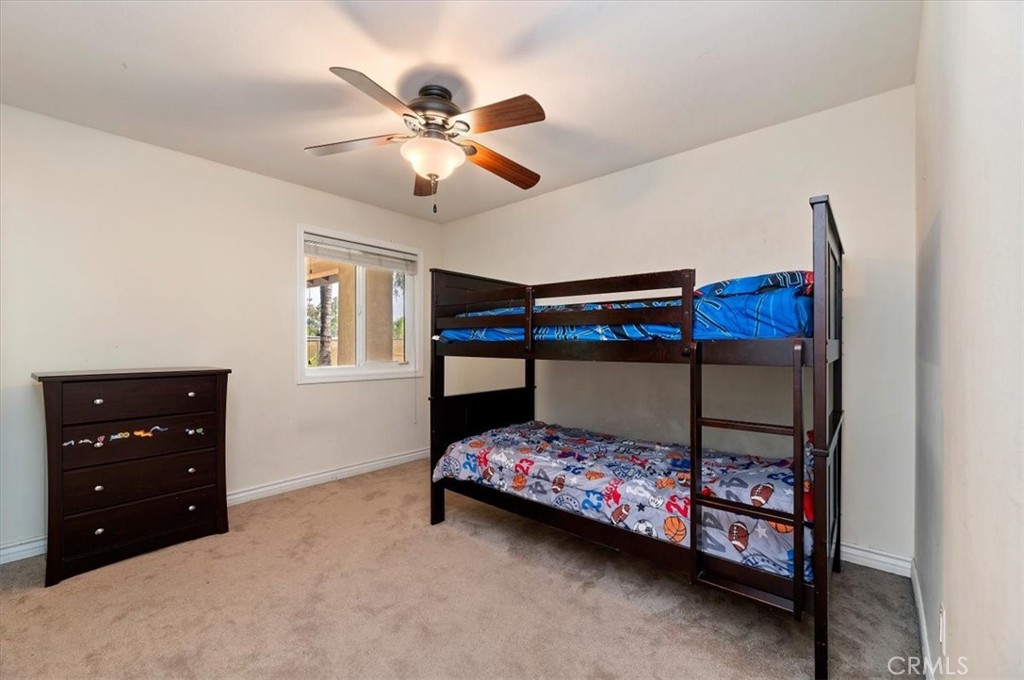 14231 Alexander Street Riverside, CA 92508 - Photo 19 of 36 a bedroom with a bed and a chandelier