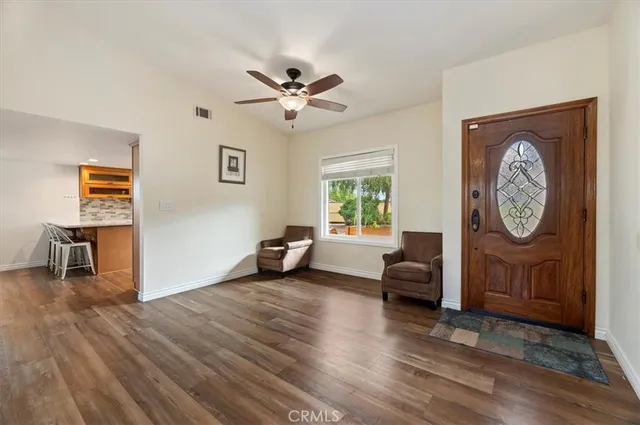 a view of a livingroom with furniture a ceiling fan and wooden floor