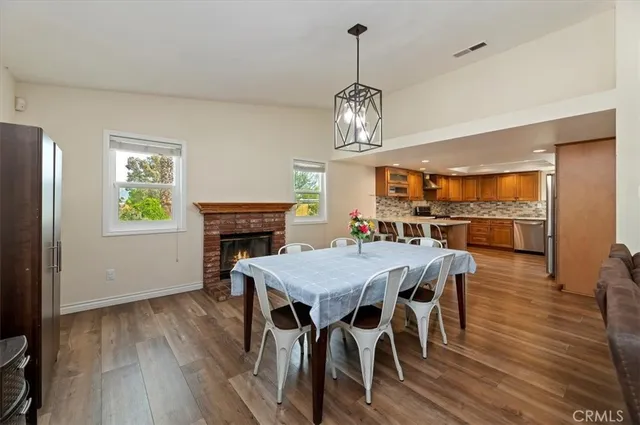 a view of a dining room with furniture a chandelier and wooden floor
