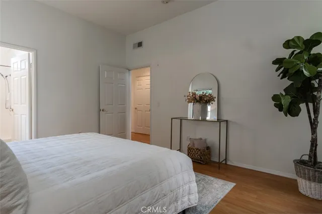 a bedroom with a bed and a potted plant