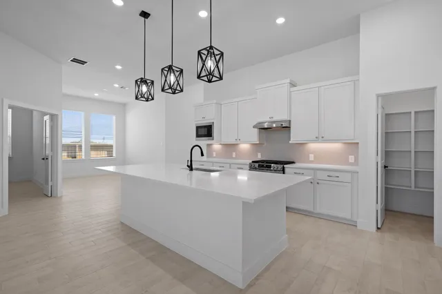 a kitchen with a sink counter top space cabinets and stainless steel appliances