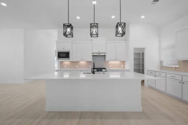 a kitchen with stainless steel appliances granite countertop a sink a stove and a refrigerator