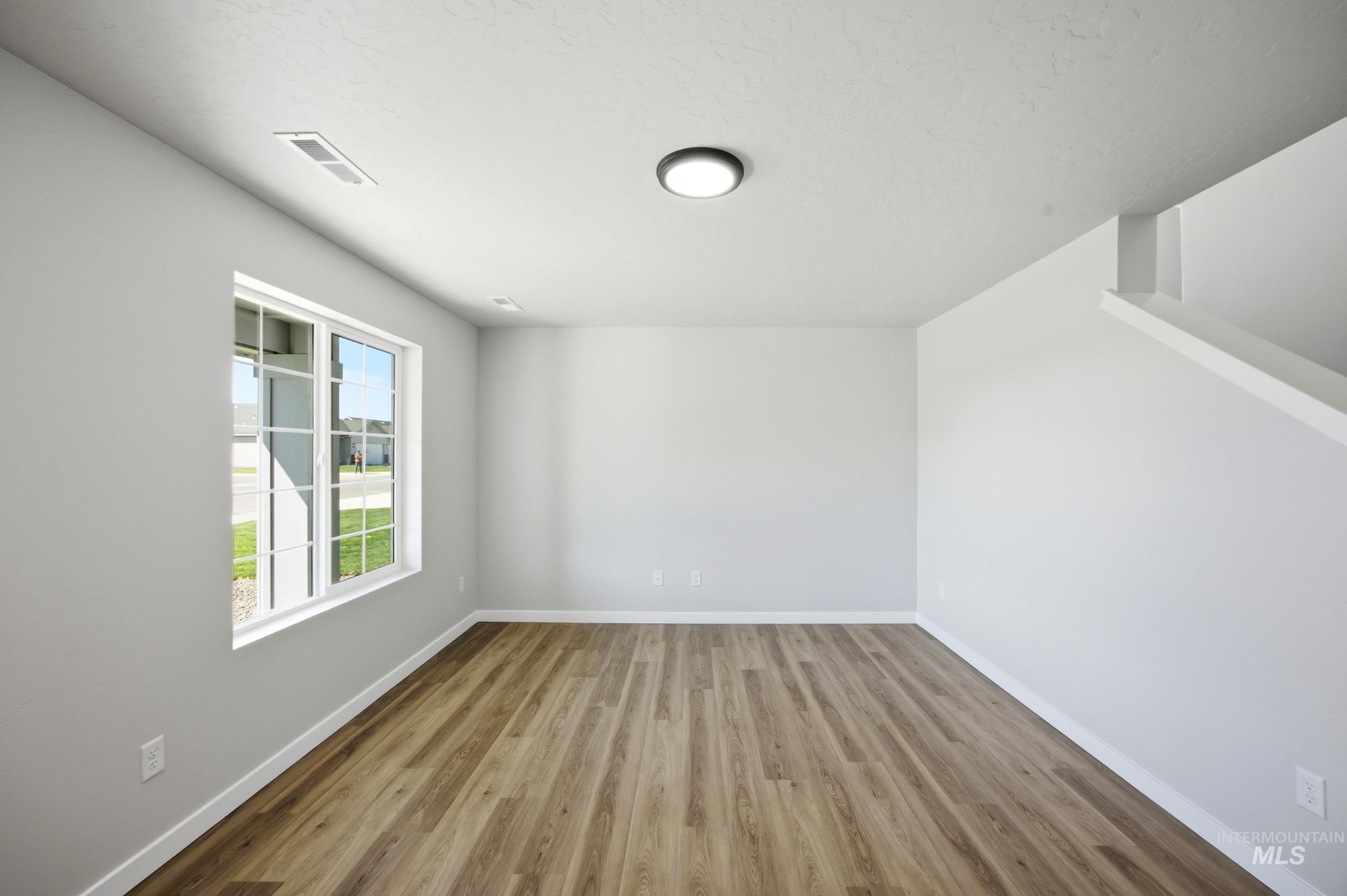 13333 Bank Street Caldwell, ID 83607 - Photo 3 of 29 Wood-finish flooring, white trim, recessed ceiling lighting, and a window with a white frame