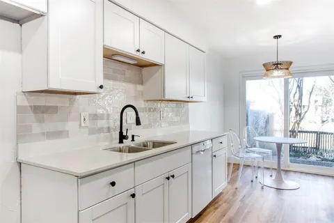 a kitchen with a sink cabinets and wooden floor
