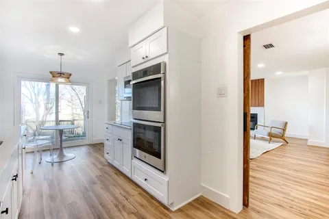 a open kitchen with a sink and wooden floor