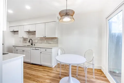 a kitchen with table chairs cabinets and stainless steel appliances
