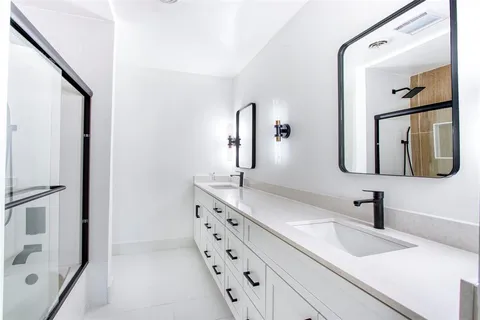 a bathroom with a double vanity sink mirror and