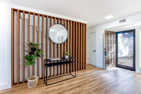 a view of a hallway with wooden floor and stairs