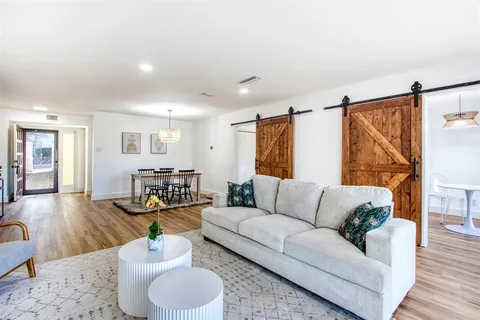 a living room with furniture and a wooden floor