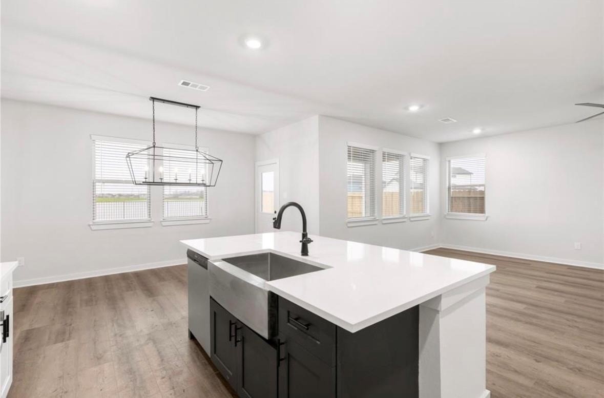 6427 Bolinas Court Rosharon, TX 77583 - Photo 6 of 23 a kitchen with stainless steel appliances granite countertop a sink a window and wooden floor