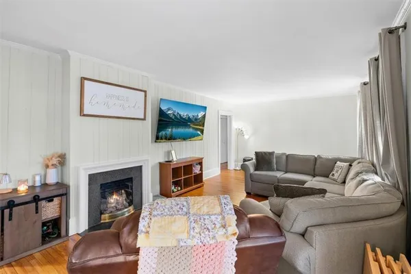 a living room with furniture a flat screen tv and a fireplace
