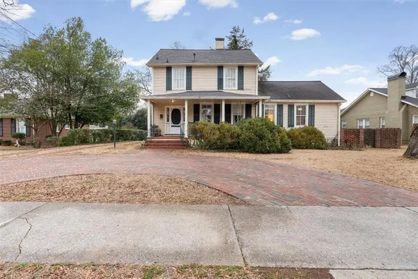 a front view of a house with a yard and trees