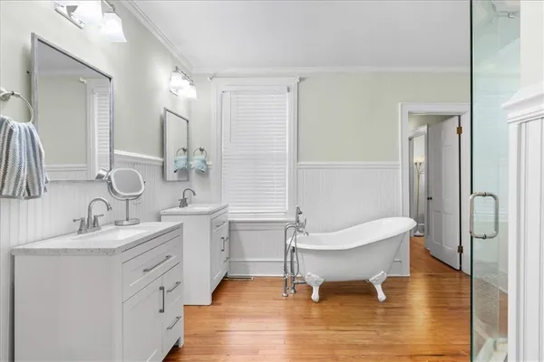 a spacious bathroom with a double vanity sink a mirror and a shower