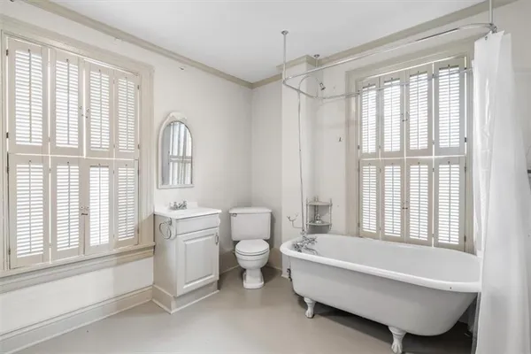 a spacious bathroom with a bathtub a toilet and a window