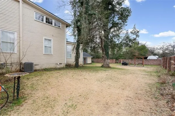 a view of a house with a yard and large tree
