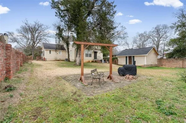 a view of a yard with a house and a large tree