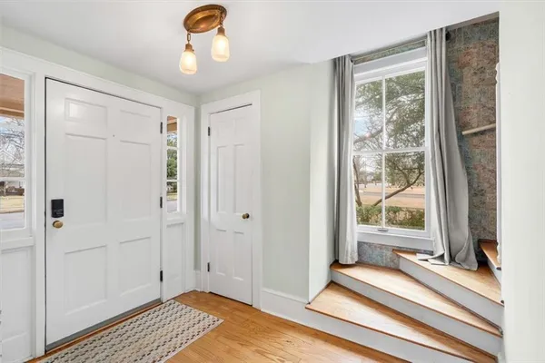 a view of a bedroom with wooden floor and windows