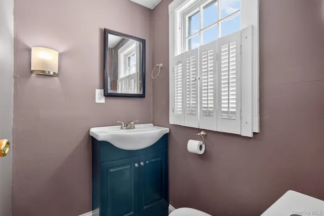 a bathroom with a sink toilet and mirror