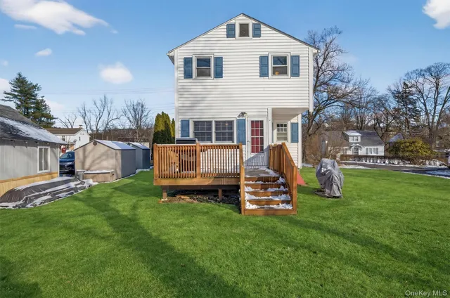 a view of a house with a yard and a large tree