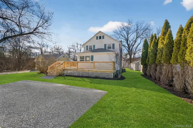 a front view of a house with garden and trees