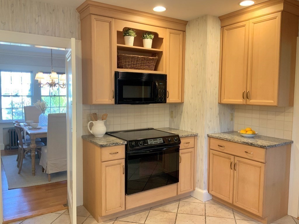 31 Grandview Road Arlington, MA 02476 - Photo 10 of 22 a kitchen with granite countertop a stove top oven microwave and cabinets