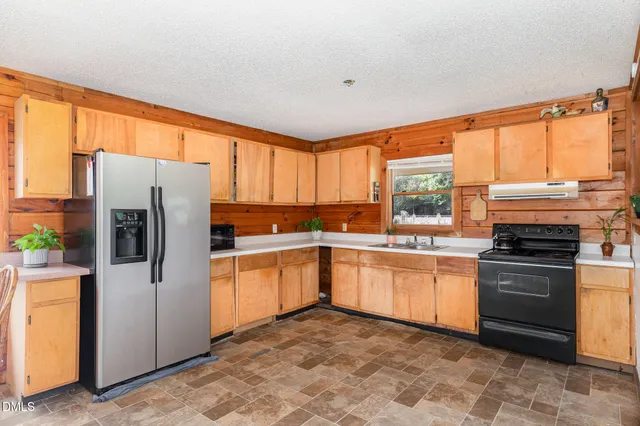 a kitchen with stainless steel appliances granite countertop a refrigerator sink and stove