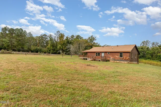 a view of a large pool with lawn chairs under an umbrella