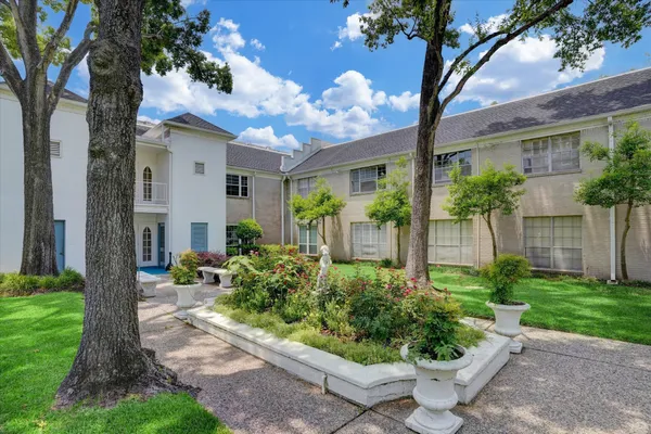 a front view of a house with a yard and potted plants