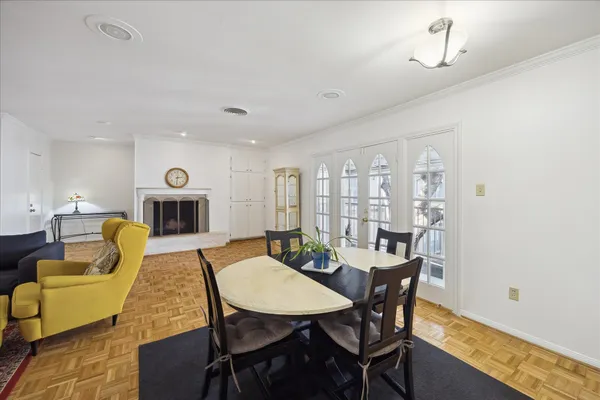a view of a dining room with furniture a fireplace and wooden floor