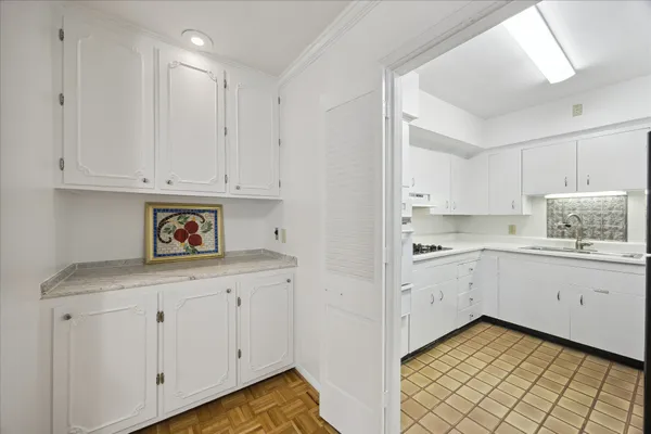 a kitchen with granite countertop white cabinets and white appliances